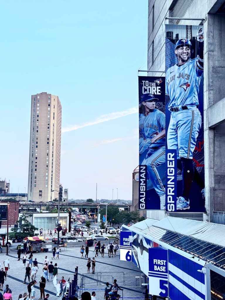 A crowd of people walking down a street next to tall buildings