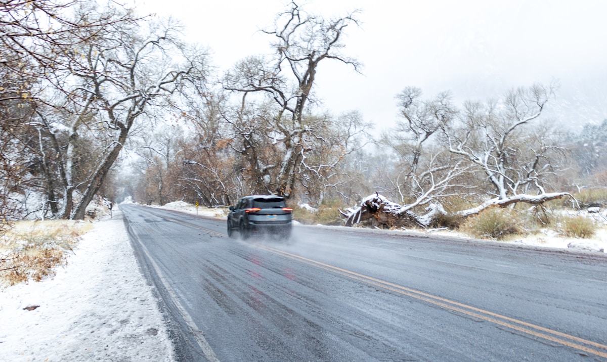 Car driving on a wet road in snowy weather