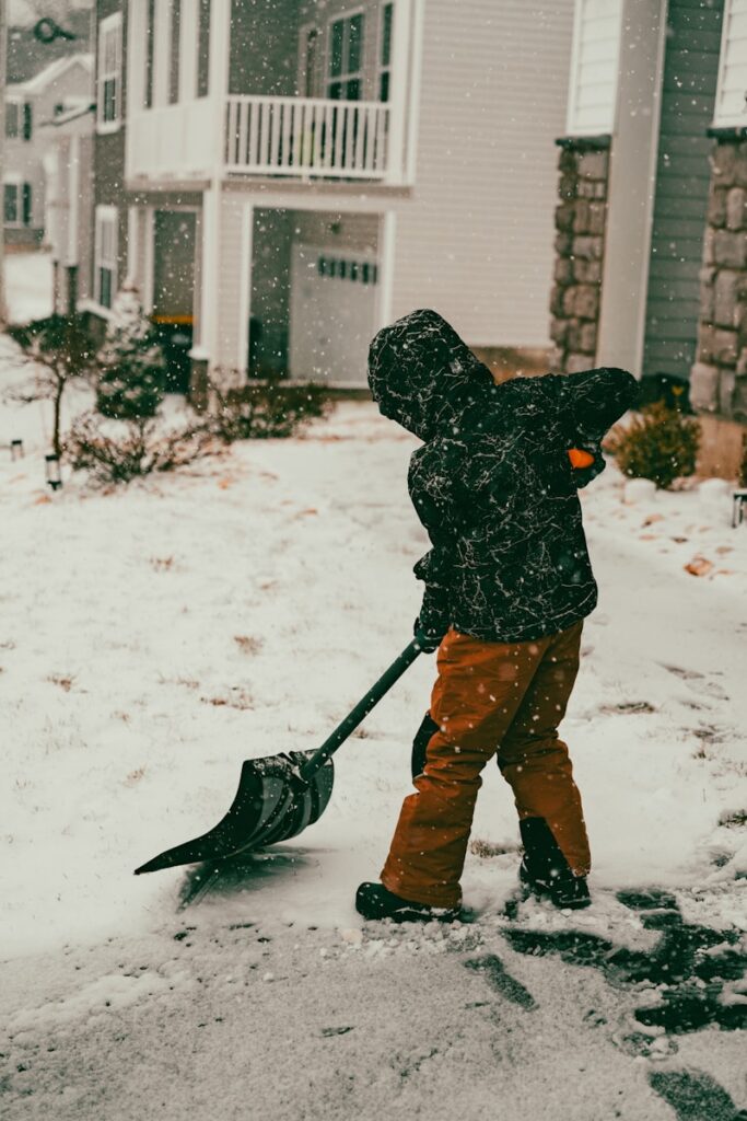 a person with a snow shovel in the snow