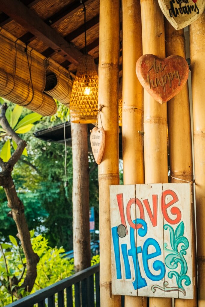 a sign that says love life hanging on a bamboo wall