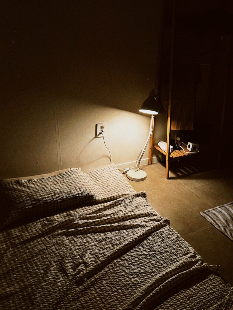 Bed with checkered blanket and a lamp