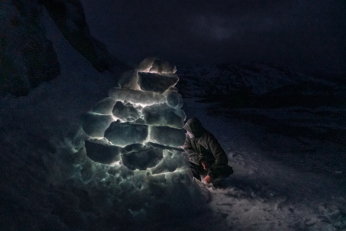 A person standing in the snow at night