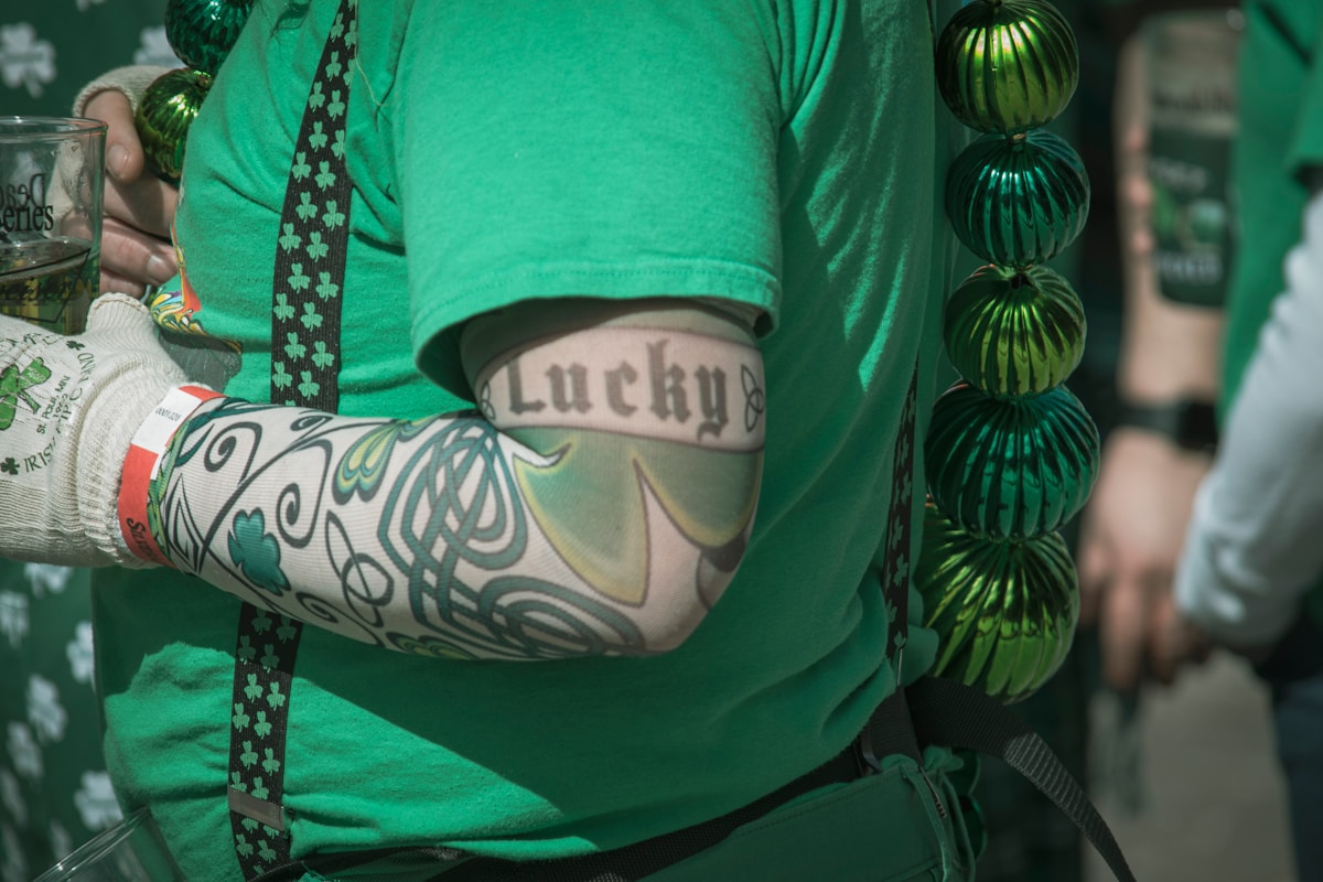 a person wearing a green shirt with a tattoo on it