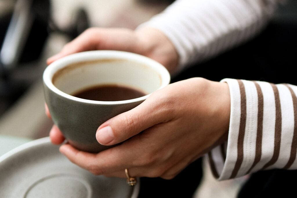 Hands holding a warm cup of coffee
