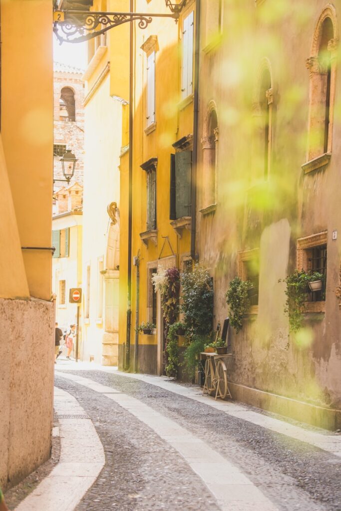 A woman walking down a street next to tall buildings