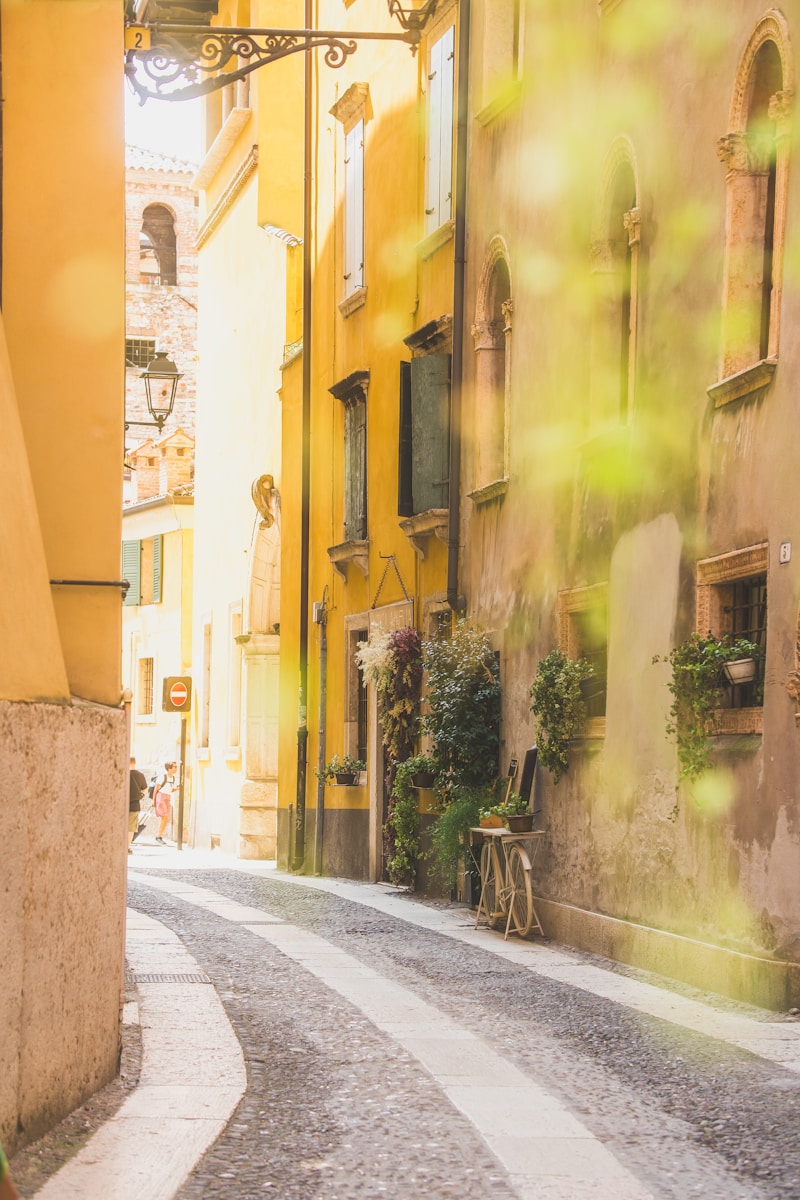 A woman walking down a street next to tall buildings